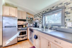 波特兰Upscale NE Portland Guesthouse的厨房配有不锈钢冰箱和水槽