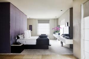 悉尼建业酒店的一间卧室配有一张床、一张书桌和一台电视。