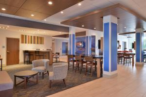 卡特湖奥马哈机场智选假日套房酒店的大堂设有桌椅和酒吧。