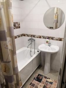 布拉戈维申斯克1 комнатная квартира的浴室配有盥洗盆、浴缸和盥洗盆