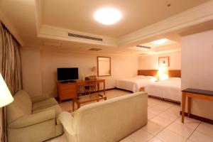 台中市金典绿园道商旅的酒店客房设有两张床、一张沙发和一台电视机。