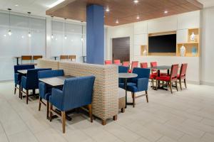 AldenHoliday Inn Express & Suites - King George - Dahlgren, an IHG Hotel的用餐室配有桌椅和平面电视。
