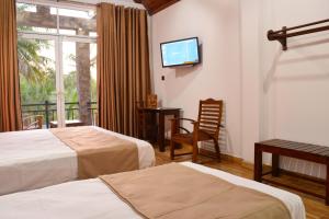 波隆纳鲁沃Monarch Residence的酒店客房设有两张床和一台平面电视。