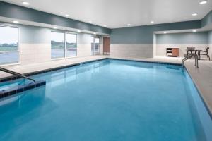 ElkhornHoliday Inn Express & Suites - Elkhorn - Lake Geneva Area, an IHG Hotel的蓝色的游泳池,位于酒店客房内