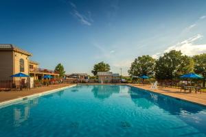 PapinHoliday Inn Club Vacations Timber Creek Resort at De Soto的一个带桌子和遮阳伞的大型蓝色游泳池