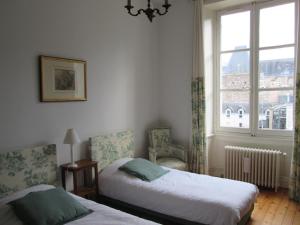 昂热Chambre d'Hôtes Marchand的一间卧室设有两张床和窗户。