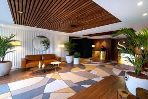 尼斯圣文森特瑟尔酒店的大堂配有沙发、桌子和植物