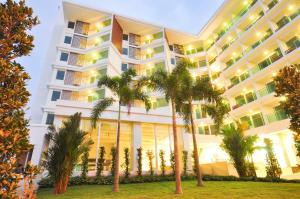 北芭堤雅Vareena palace hotel的前面有棕榈树的酒店