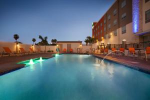 麦卡伦Holiday Inn Express & Suites - McAllen - Medical Center Area, an IHG Hotel的夜间在酒店前的游泳池
