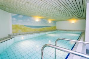 凯图姆Gemütliche Wohnung unter Reet mit Pool und Sauna in Keitum的墙上画画的大型游泳池