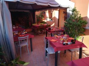 卡布拉斯西尼斯雕像旅馆的庭院里的餐厅,配有红色的桌椅