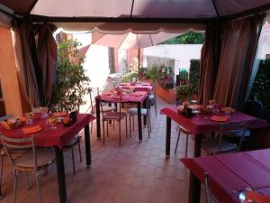 卡布拉斯西尼斯雕像旅馆的一间设有红色桌椅和遮阳伞的餐厅