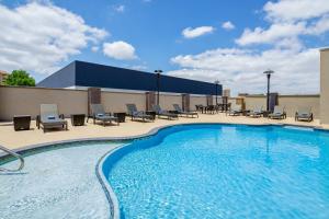 拉伯克Holiday Inn Express & Suites Lubbock Central - Univ Area, an IHG Hotel的一个带桌椅的大型游泳池
