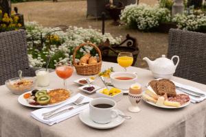 盖布维莱尔Domaine de Beaupré - Hotel The Originals Relais的一张桌子,上面有早餐食品和饮料