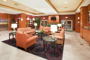 大章克申机场假日套房酒店的酒店大堂设有橙色椅子和桌子。