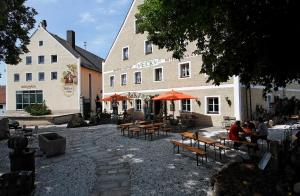 Böbrach艾克酿酒厂旅馆的一组桌子和长凳在建筑物前