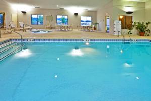 马斯科吉马斯科吉快捷假日&套房酒店的在酒店房间的一个大型蓝色游泳池
