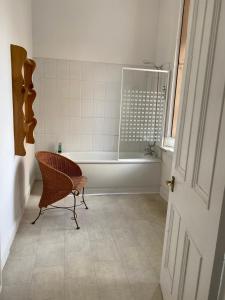 格拉斯哥格鲁吉亚庄园的带浴缸的浴室和椅子。
