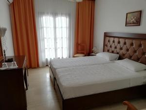 瓦西里亚斯天堂酒店的一间卧室设有一张大床和一个大窗户