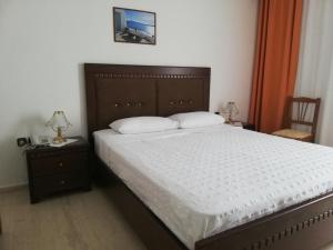 瓦西里亚斯天堂酒店的卧室配有一张床,墙上配有电视。