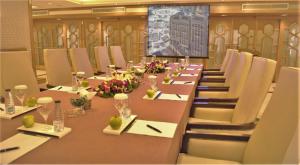 麦加Makkah Hotel的大型会议室,配有长桌子和椅子