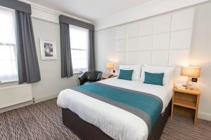 滨海克拉克顿金斯克利夫酒店的酒店客房配有一张带蓝色枕头的大床