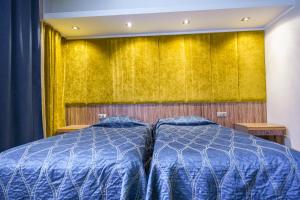 哈普萨卢弗拉马雷海水浴场Spa酒店的一间卧室设有两张床和黄色的墙壁