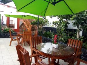 万查科Hospedaje Fremiott的一个带桌椅和绿色遮阳伞的庭院