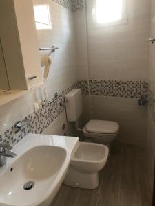 利多迪耶索罗美式酒店的浴室配有白色水槽和卫生间。