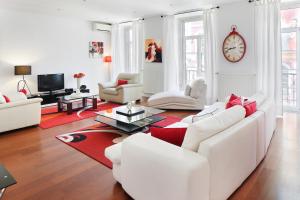 里斯本里斯本冷塔尔齐亚铎酒店的客厅配有白色家具和红色地毯。