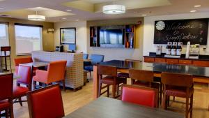 Sioux Center希尔中心智选假日酒店的一间带桌椅的餐厅和一间酒吧