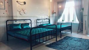 绥和市Bí Đỏ homestay的一间卧室配有两张带绿床单和地毯的床。