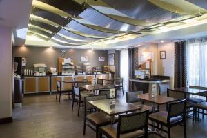 牛津Holiday Inn Express & Suites - Oxford, an IHG Hotel的一间带桌椅和柜台的餐厅
