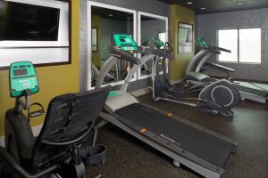 堪萨斯城堪萨斯城机场智选假日套房酒店的一间健身房,里面配有几台跑步机
