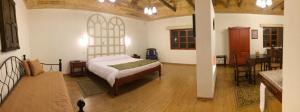 伊瓦拉卡罗拉维庄园酒店的一间卧室设有一张床和一间用餐室
