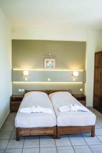 提诺斯Filoxenia的一间卧室配有两张带毛巾的床