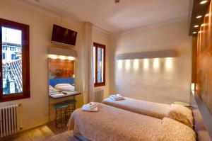 威尼斯洛坎达西尔瓦酒店的酒店客房设有两张床和盥洗盆