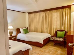 苏林海滩苏林湾旅馆的酒店客房,配有两张床和椅子