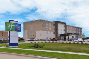 马歇尔敦Holiday Inn Express & Suites - Marshalltown, an IHG Hotel的前面有标志的酒店大楼