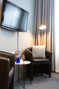 雷克桑德莱克桑德酒店的客厅配有两把椅子和墙上的电视