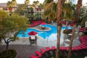 拉斯维加斯Tuscany Suites & Casino的享有游泳池的顶部景致,设有红色椅子和树木