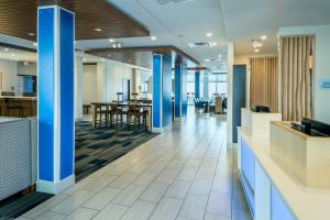 梅德福Holiday Inn Express & Suites - Medford, an IHG Hotel的大堂设有蓝色的圆柱和桌子