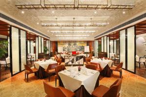 无锡无锡太湖华邑酒店的一间设有白色桌椅和窗户的用餐室