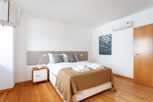 里斯本FLH Liberdade Contemporary Flat的一间铺有木地板的白色卧室,配有一张床