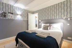 里斯本FLH Bairro Alto Elegant Apartment的一间卧室配有一张带蓝色毯子的大床