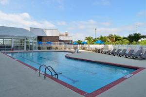 大洋城大洋城智选假日酒店的一座带椅子的大型游泳池和一座建筑