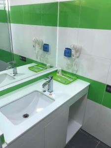 杭州7天连锁酒店(杭州萧山国际机场西大门店)的浴室设有白色水槽和镜子