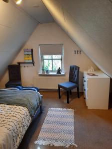 哈克斯卑尔根familiehuis Benboverijssel的阁楼卧室配有床和椅子