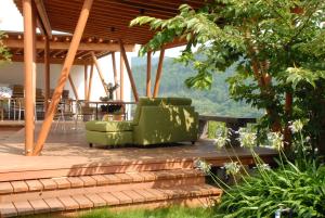 河津町禅意温泉酒店的一个带两张绿色椅子和一张桌子的甲板