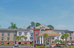 彭萨科拉Holiday Inn Express & Suites Pensacola West I-10, an IHG Hotel的一座酒店大楼前面有棕榈树